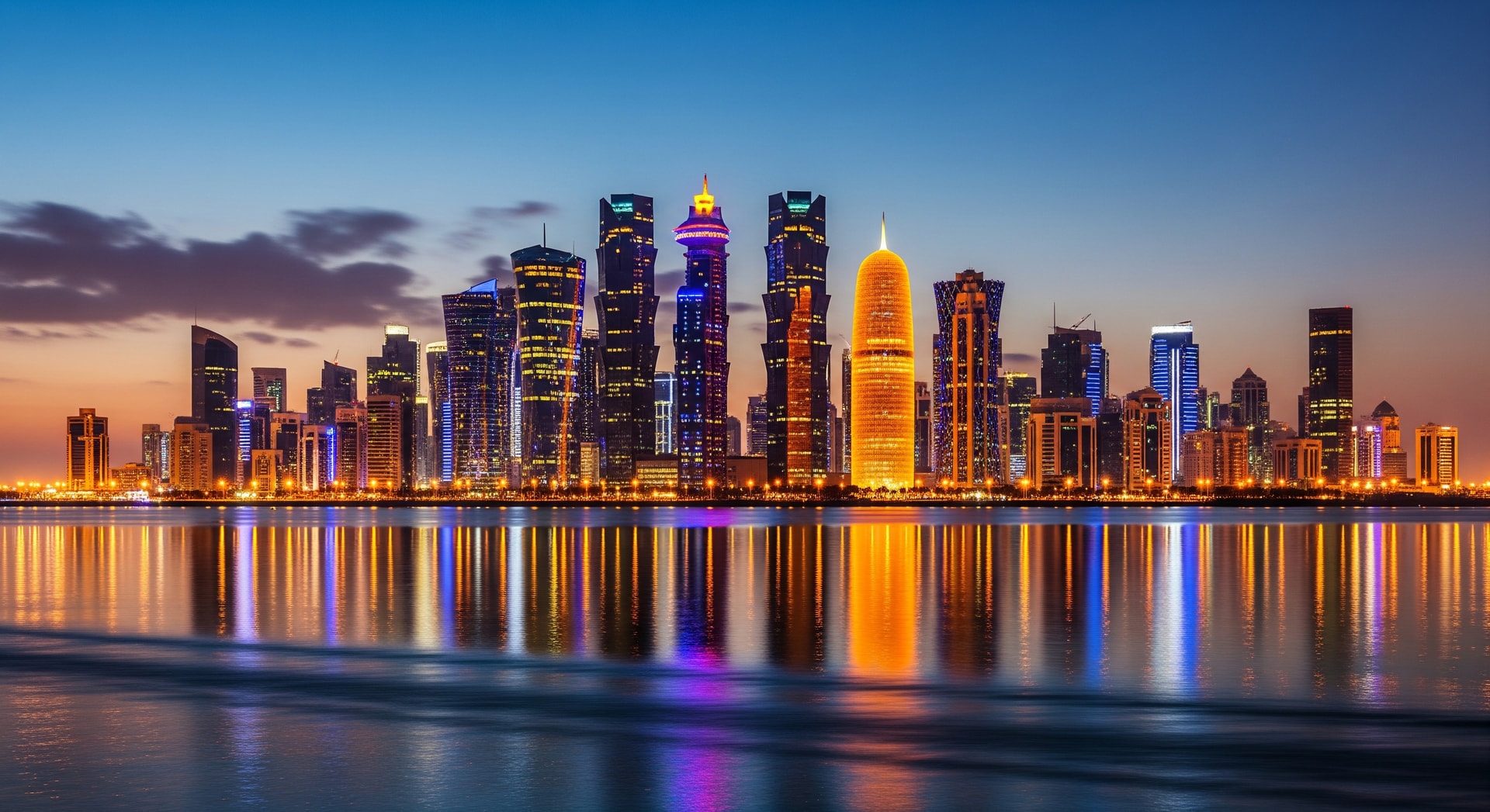 Doha Qatar skyline at night with iconic modern skyscrapers reflecting on the water