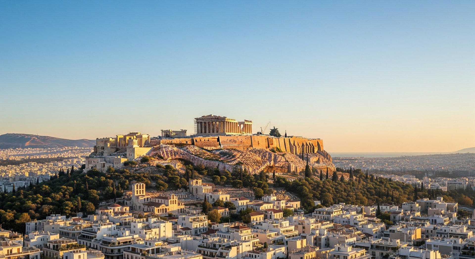 Panoramic view of Athens with the Acropolis and Parthenon against a clear sky representing Greece's rich cultural and institutional heritage